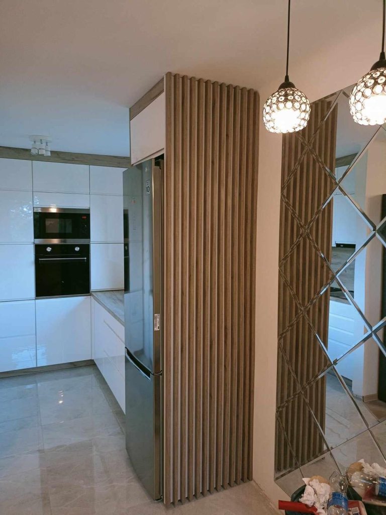 Moderne Küche mit Holzarbeitsfläche, Gläsern im Regal und einem Essbereich.